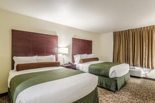 a hotel room with two beds and a window at Cobblestone Inn & Suites - Bridgeport in Bridgeport