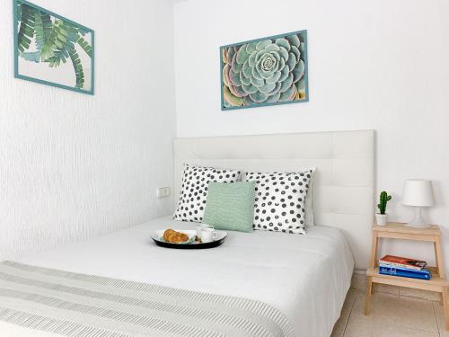 a bedroom with a bed with a bowl of food on it at Cosy Flats Luceros in Alicante