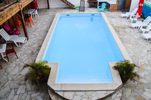 una piscina vacía en un patio con sillas en Résidence fruit de la passion Caliente, en Sainte-Anne