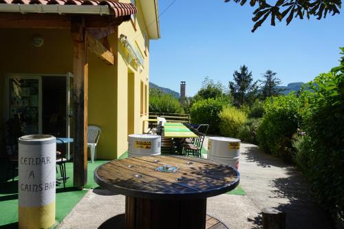 a wooden table sitting outside of a building at Gîte des Grands Causses in Millau
