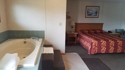 a hotel room with a bed and a bath tub at Milwaukie Inn Portland South in Milwaukie