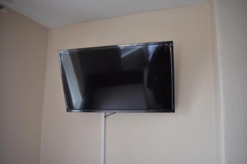 a flat screen tv hanging on a wall at Cotswold Valley Aparthotel in Stroud