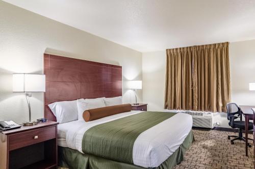 a hotel room with a large bed and a desk at Cobblestone Inn & Suites - Bridgeport in Bridgeport