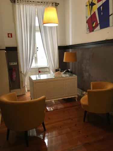 a living room with a table and chairs and a window at Hotel Jardim in Coimbra