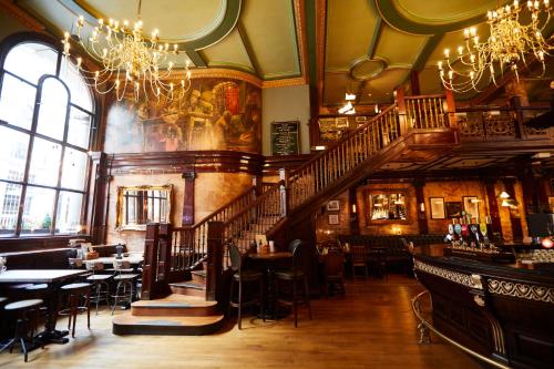 a restaurant with a staircase and tables and chairs at Counting House in London