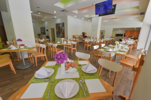 a dining room with tables and chairs and a tv at HB Córdoba in Córdoba