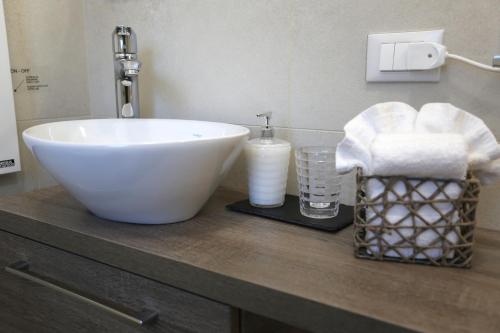 a bathroom with a white sink and a basket of towels at DB Apartments - Dabasso in Mestre