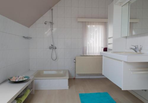 a white bathroom with a tub and a sink at Prachtig herenhuis uit 1925 in Nijlen