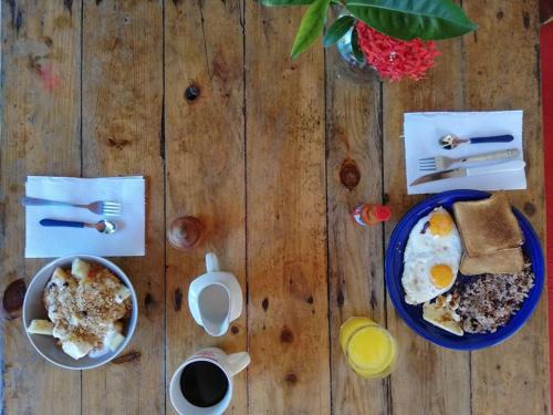 拉斯彭尼塔斯Caracolito Hostal的一张木桌,上面放着两盘鸡蛋和烤面包