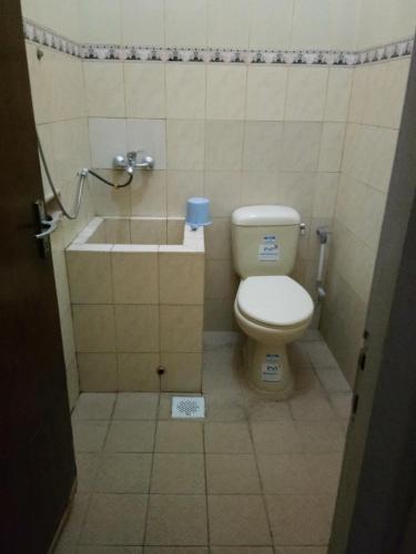 a small bathroom with a toilet and a sink at Prayogo Lama Family GH Prawirotaman in Yogyakarta