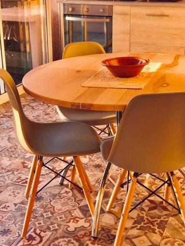 a wooden table with four chairs and a bowl on it at Casa Limone in Quartu sant Elena, Capitana, with sea view! in Capitana