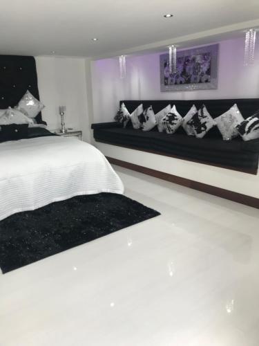a bedroom with a white bed and a bench at Browns in Peterhead