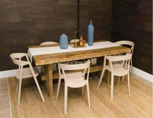 a wooden table with chairs and blue vases on it at Casa Paracas in Paracas