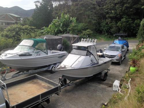two boats on a trailer and a car in a driveway at Pacific Harbour Lodge in Whangaroa