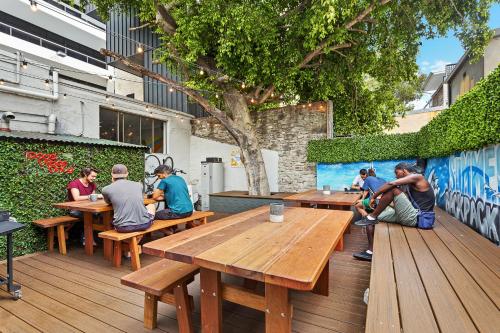 a group of people sitting at tables on a deck at Summer House Kings Cross in Sydney