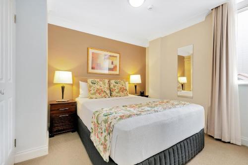a hotel room with a bed and a lamp at Manor Apartment Hotel in Brisbane