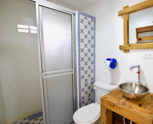 a bathroom with a toilet and a sink at QuillaHost Tropical Apartment in Barranquilla