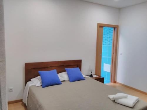 1 dormitorio con 1 cama grande con almohadas azules en Charrua do Mondego - Alojamento Local, en Penacova