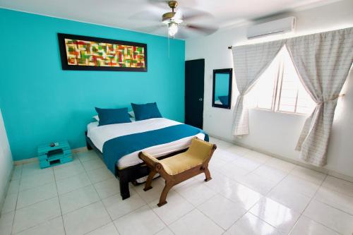 a blue bedroom with a bed and a chair at QuillaHost Tropical Apartment in Barranquilla