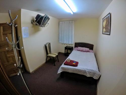 a small room with a bed and a tv at Residencial Uruguay in La Paz