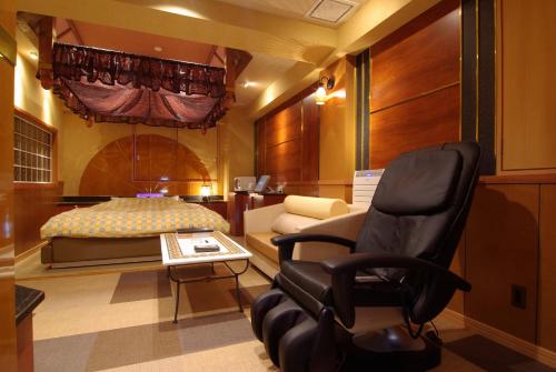 a bedroom with a bed and a chair and a bed at Shonan Sirene (Adult Only) in Hiratsuka