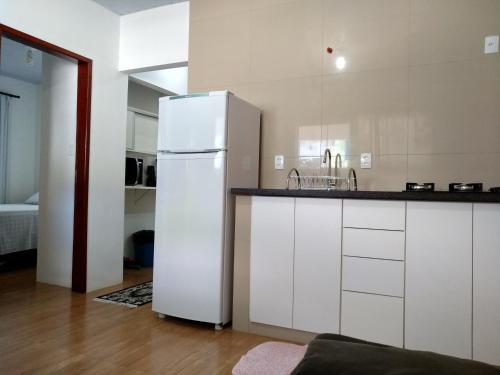 una cucina con frigorifero bianco e lavandino di Quitinete Balneário a Balneário Camboriú
