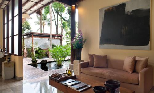 a living room with a couch and a table at Komaneka at Tanggayuda Ubud in Ubud