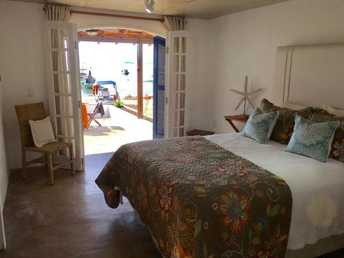1 dormitorio con 1 cama y puerta que da a un patio en Casarao da Praia, en Praia Vermelha