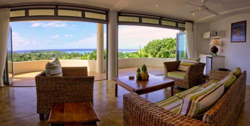 a living room with chairs and a table at Villa Maria in Rarotonga