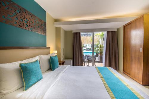 a hotel room with a large bed with blue pillows at Boracay Haven Resort in Boracay