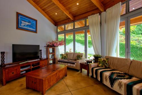 a living room with a couch and a tv at Villa Maria in Rarotonga