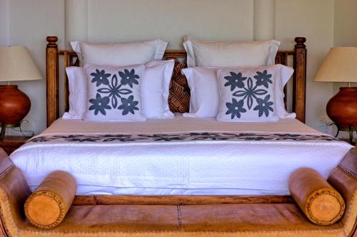 a bedroom with a bed with white and blue pillows at Villa Maria in Rarotonga