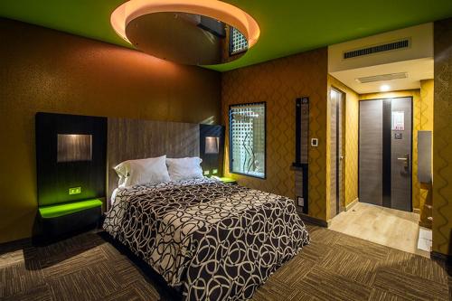 - une chambre avec un lit et un mur vert dans l'établissement HOTEL ZARAGOZA INN BOUTIQUE, à Mexico