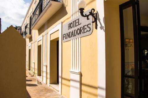 a sign on the side of a building that reads real landmarks at Hotel Fundadores in Valladolid