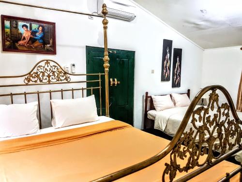 a bedroom with two beds and a chair at nDalem Gamelan in Yogyakarta