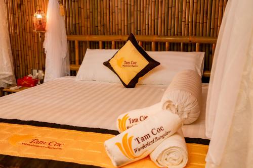 a hotel room with a bed with towels on it at Tam Coc Wonderland Bungalow in Ninh Binh