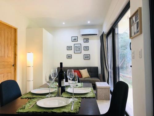a dining room with a table with wine glasses at Las Naveiras in Tamarindo