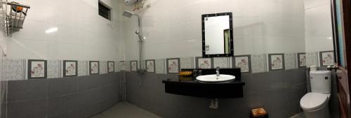 Un baño con lavabo, espejo e inodoro. en Tam Coc Thanh Dat Homestay, en Ninh Binh