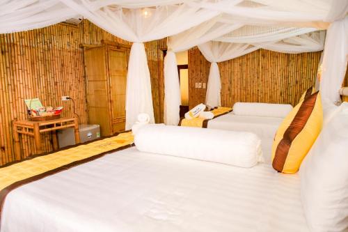 a bedroom with two white beds in a room at Tam Coc Wonderland Bungalow in Ninh Binh