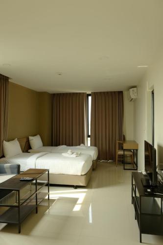 um quarto de hotel com duas camas e uma televisão em 185 Residence em Khon Kaen