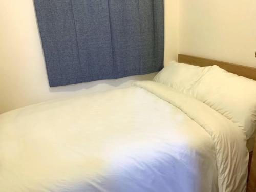 a white bed in a room with a window at The Cove Hostel - Tong Fuk Octopus in Hong Kong