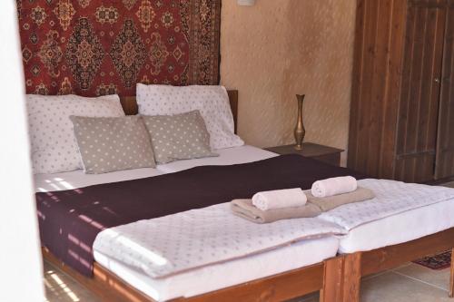 Una cama con dos toallas encima. en Sirocave barlang apartmanok, en Sirok