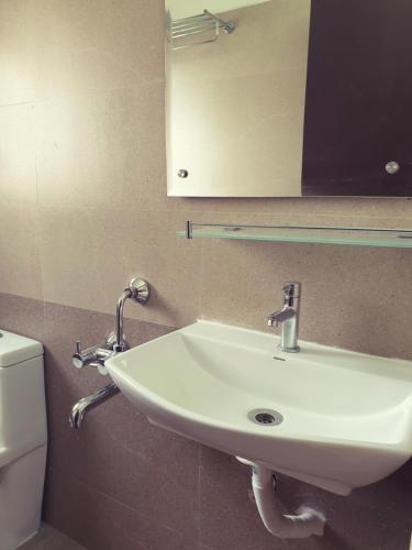 a bathroom with a sink and a mirror and a toilet at Chippy Inn in Chennai