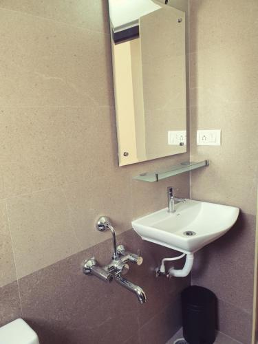 a bathroom with a sink and a mirror at Chippy Inn in Chennai