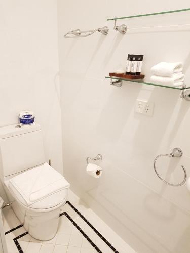a white bathroom with a toilet and a shower at The Hughenden Boutique Hotel in Sydney