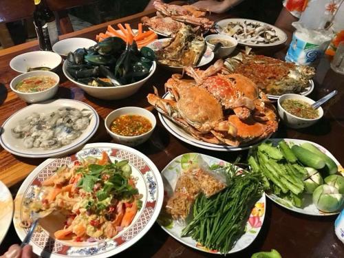 a table with many plates of food on it at Baan Chang Residence in Bang Sare