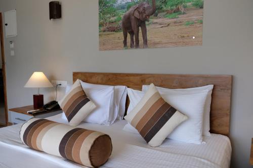 a bed with white pillows and an elephant standing on it at Twenty-Two Weligambay in Weligama