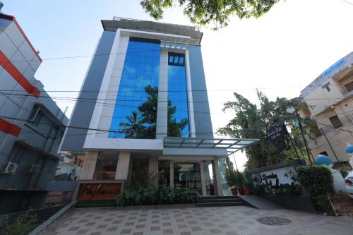 a tall building with a glass facade at Swades Myhome in Trivandrum