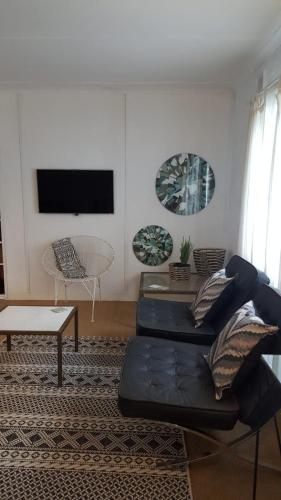 ein Wohnzimmer mit einem schwarzen Sofa und einem Tisch in der Unterkunft loft 33 in Pietermaritzburg