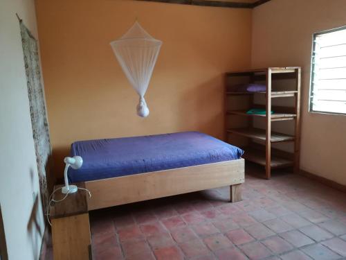 1 dormitorio con 1 cama con sábanas azules y ventana en Dario's Room1 en Kokrobite